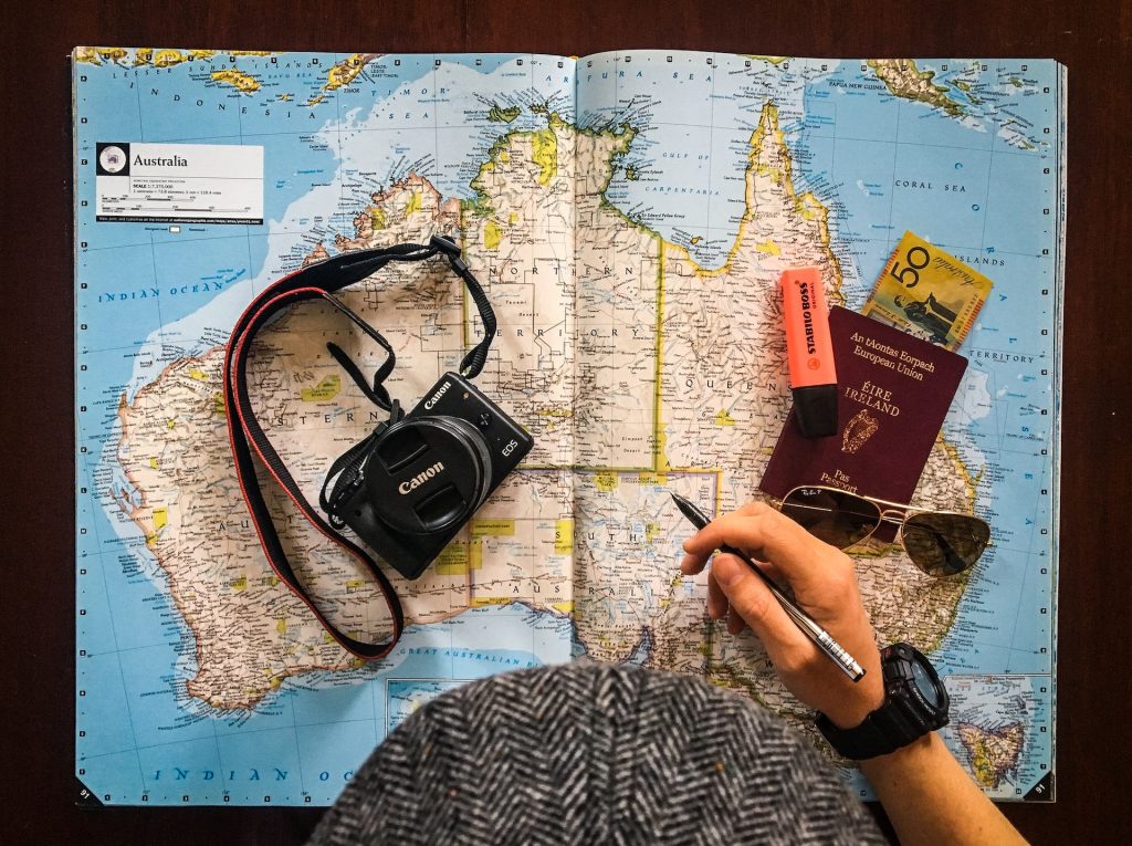 A person holding a map and a pen on a table.