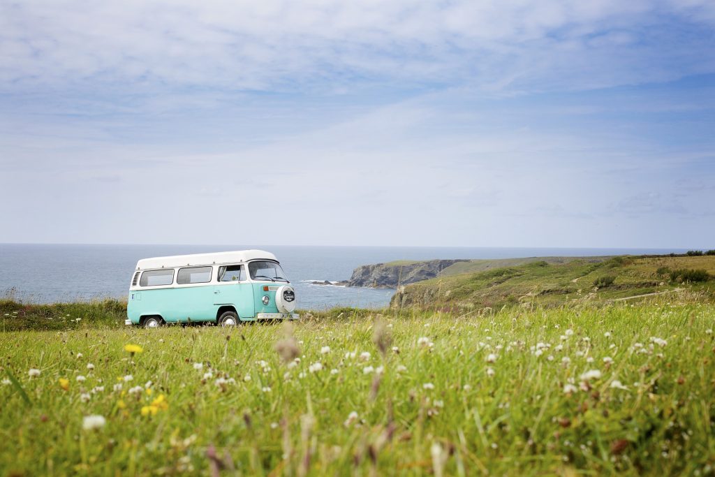 A vintage VW bus driving through a scenic landscape.