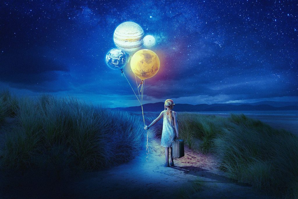 A girl stands on sand dunes at night, holding glowing baloons representing the planets.