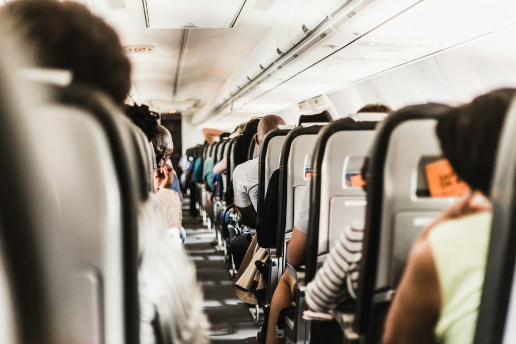 A first-person view of a busy plane cabin from your view in the aisle seat.