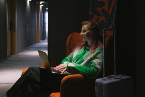 traveller staying sitting down on a couch while working